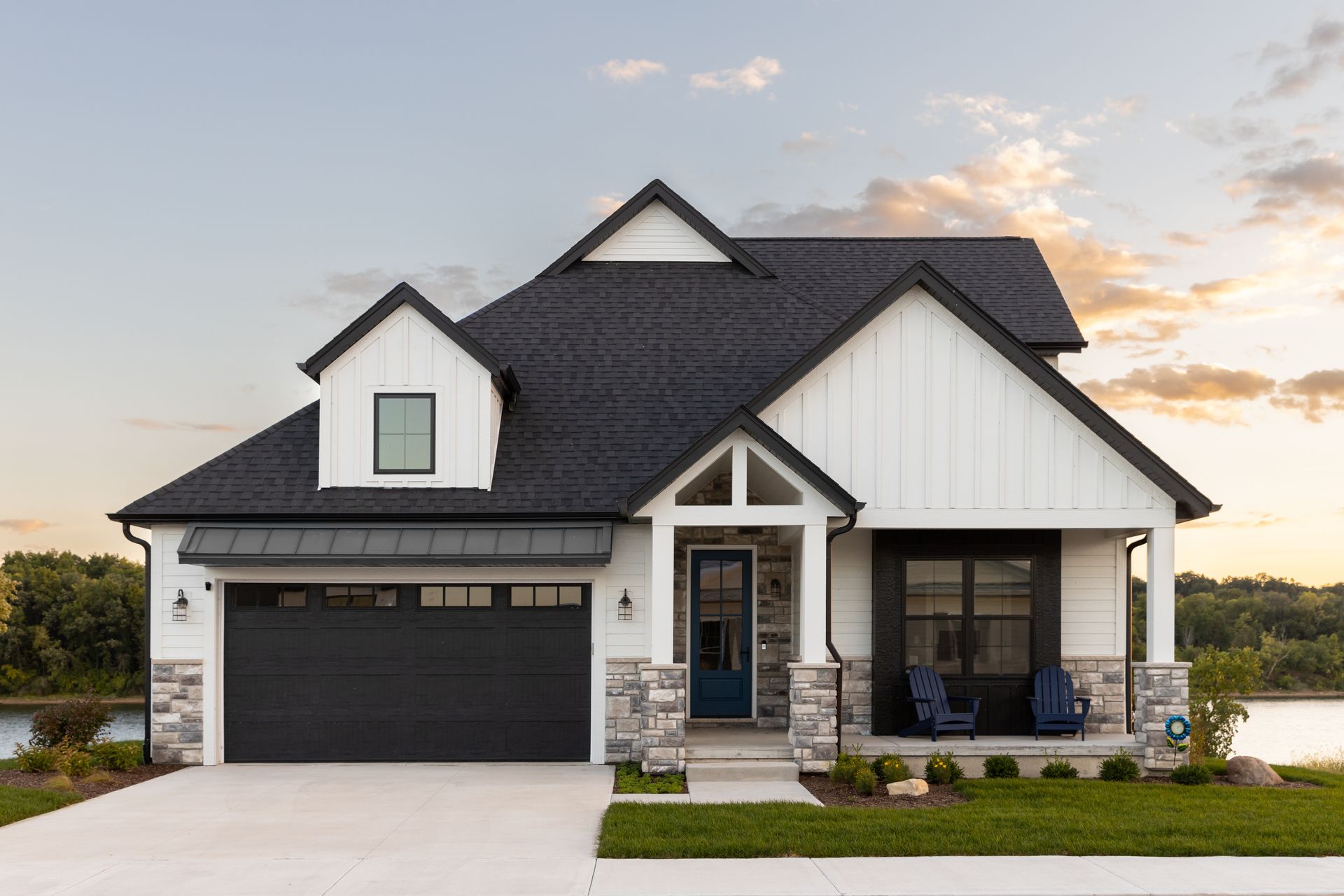 A white house with a black roof and a blue door.