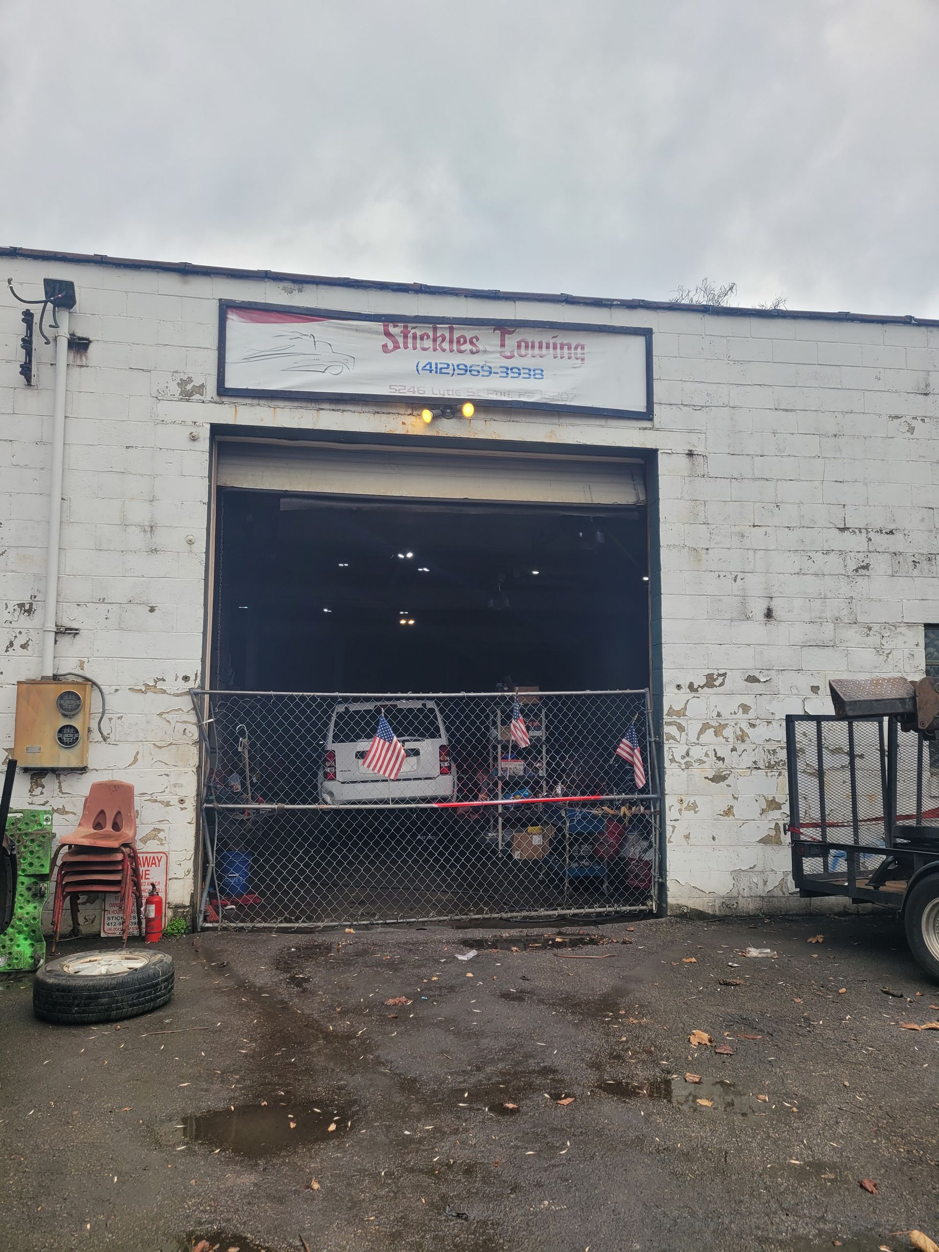 A white building with a sign that says ' shelby 's garage ' on it