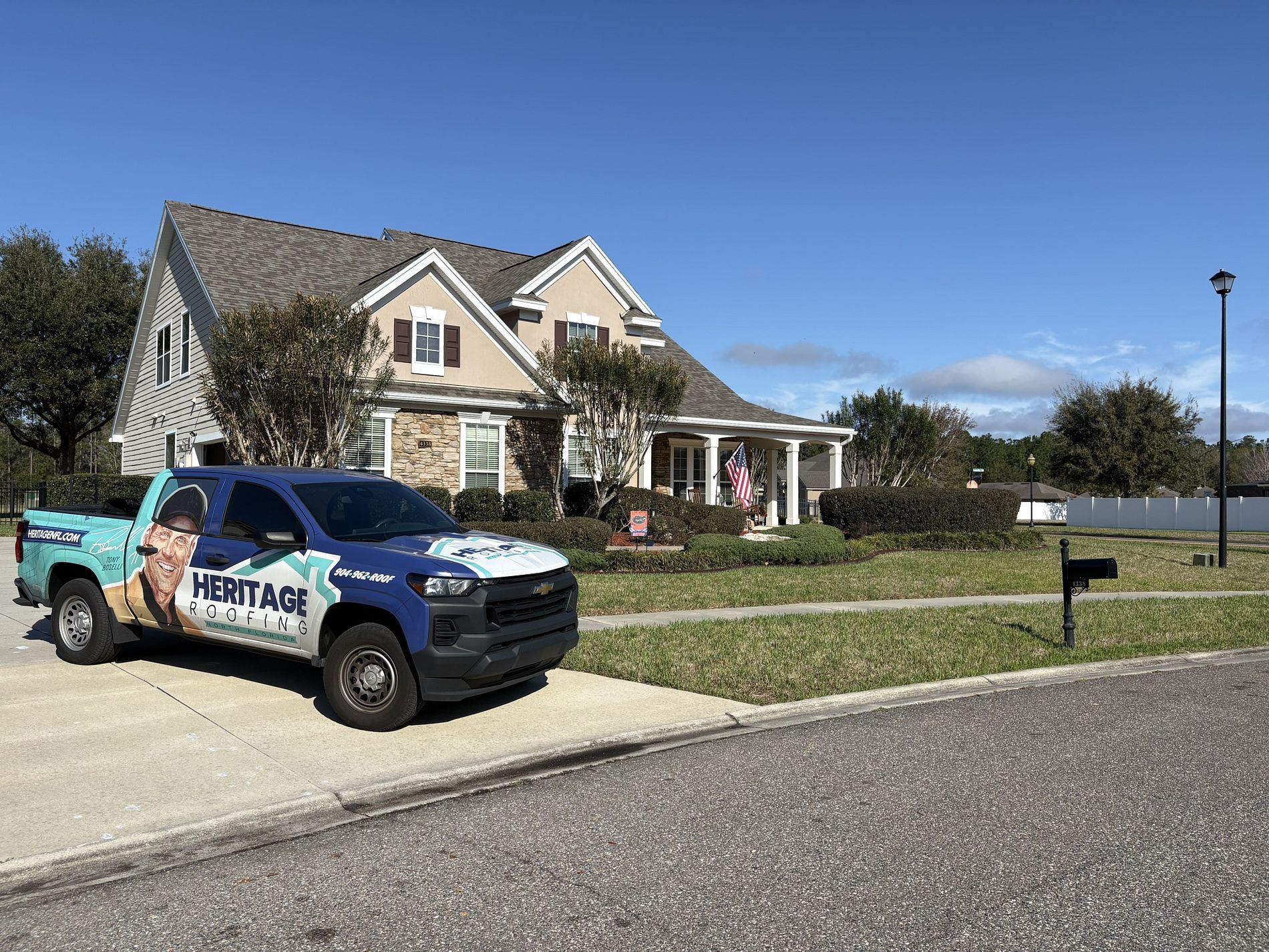 House with a blue pickup truck parked in front on a suburban street