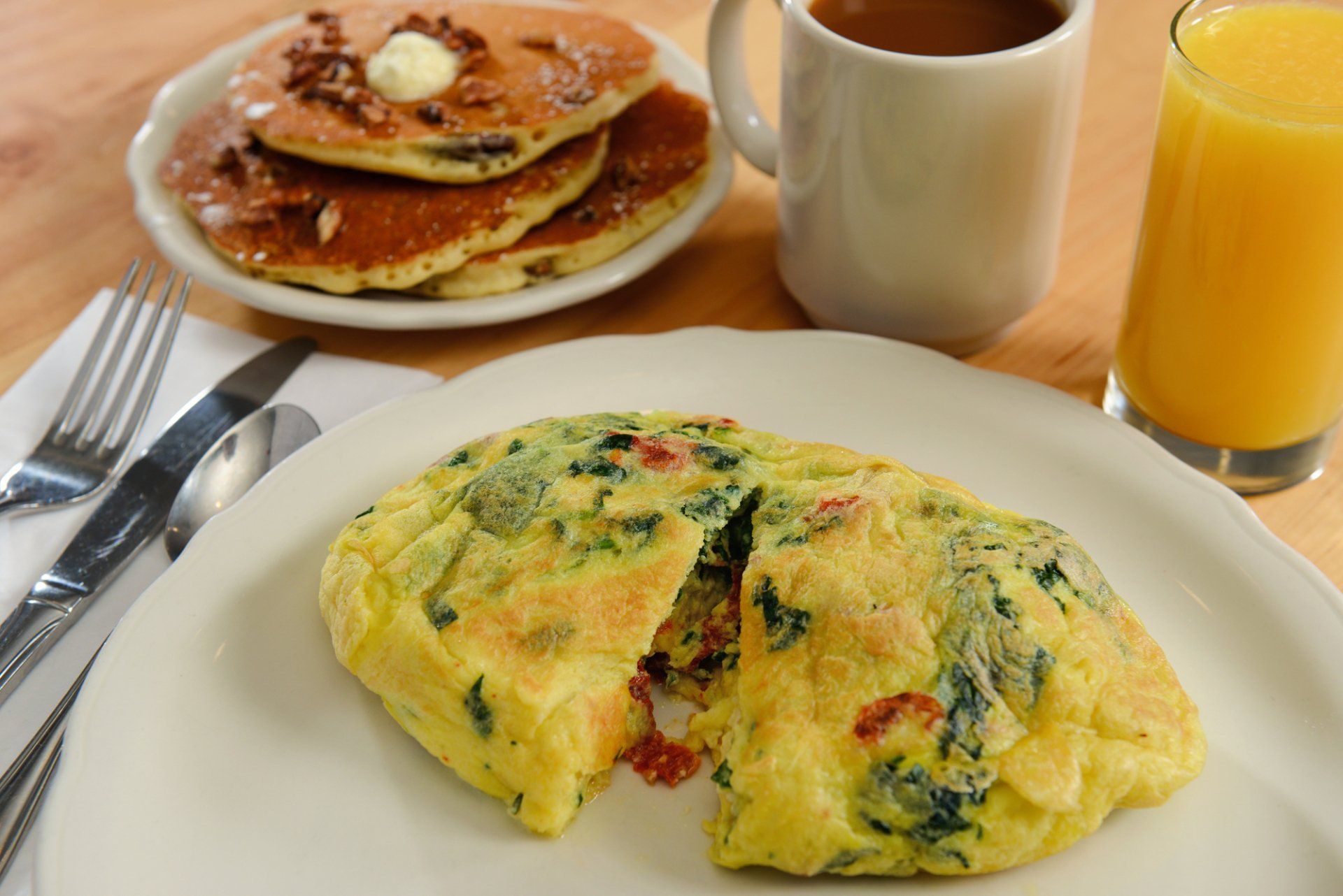 Breakfast: spinach and tomato omelet, pancakes with butter, coffee, orange juice.