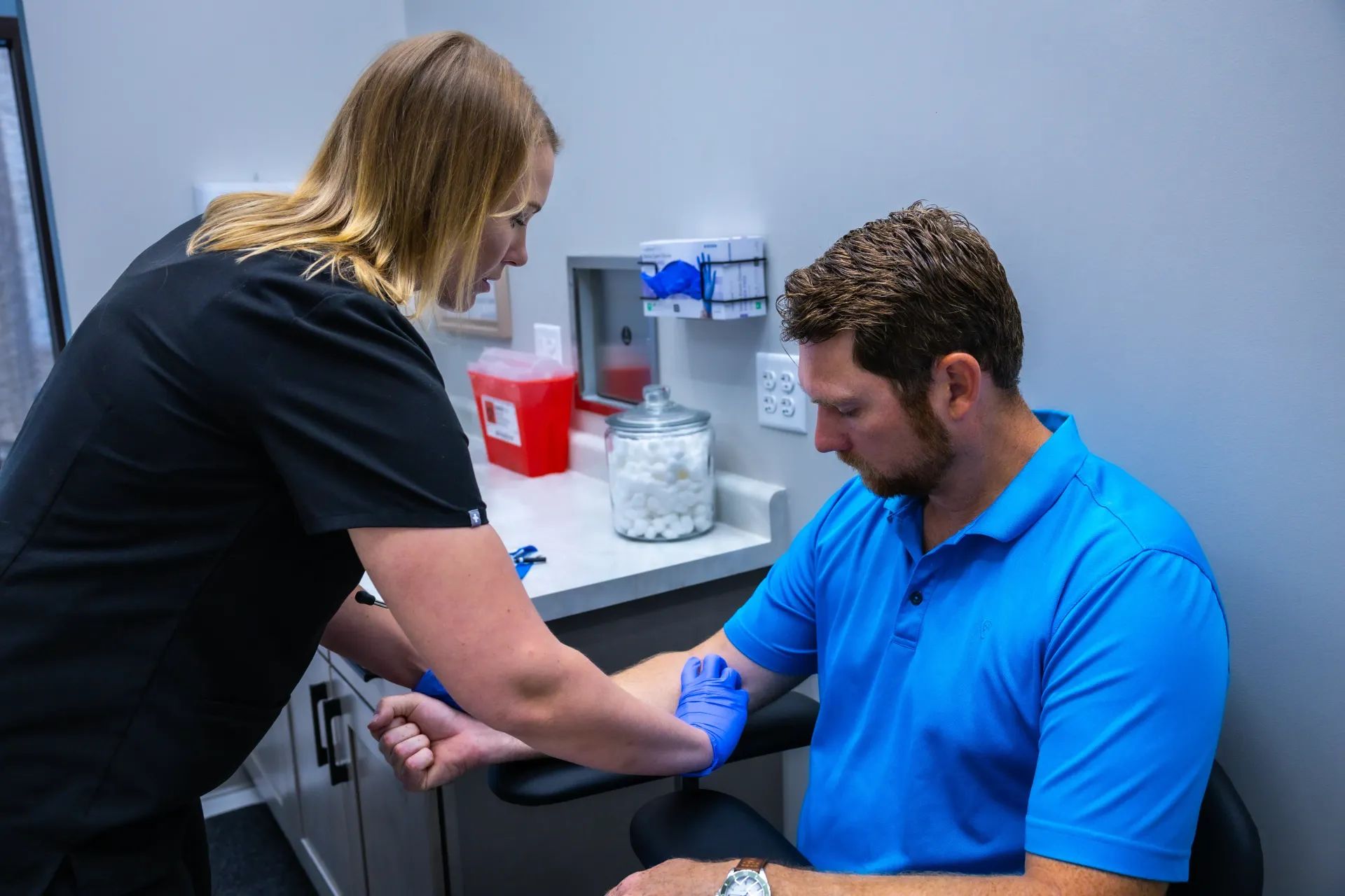 Nurse taking a man’s blood pressure in a clinic room