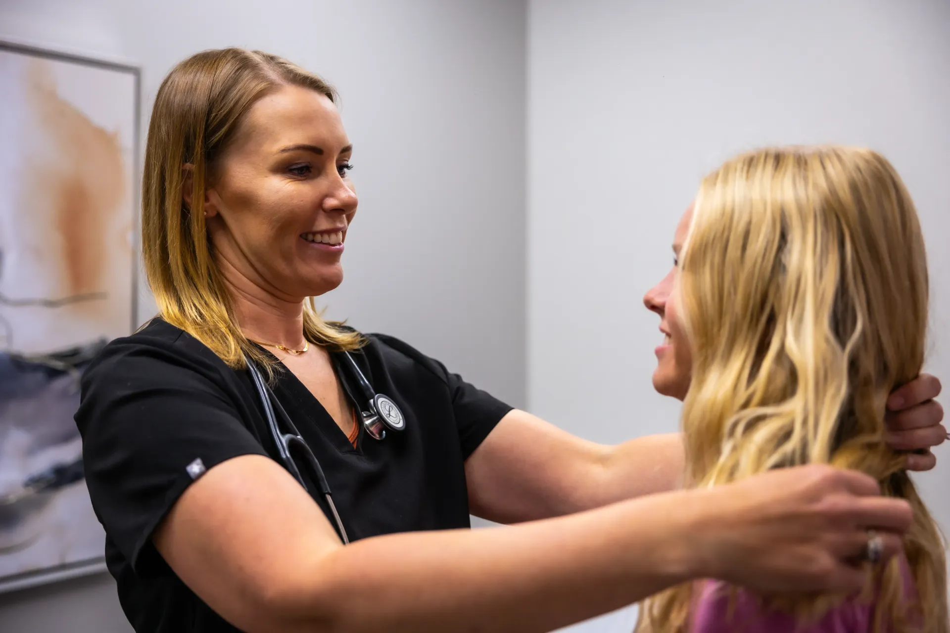 Clinician uses a stethoscope to examine a seated patient in a medical office