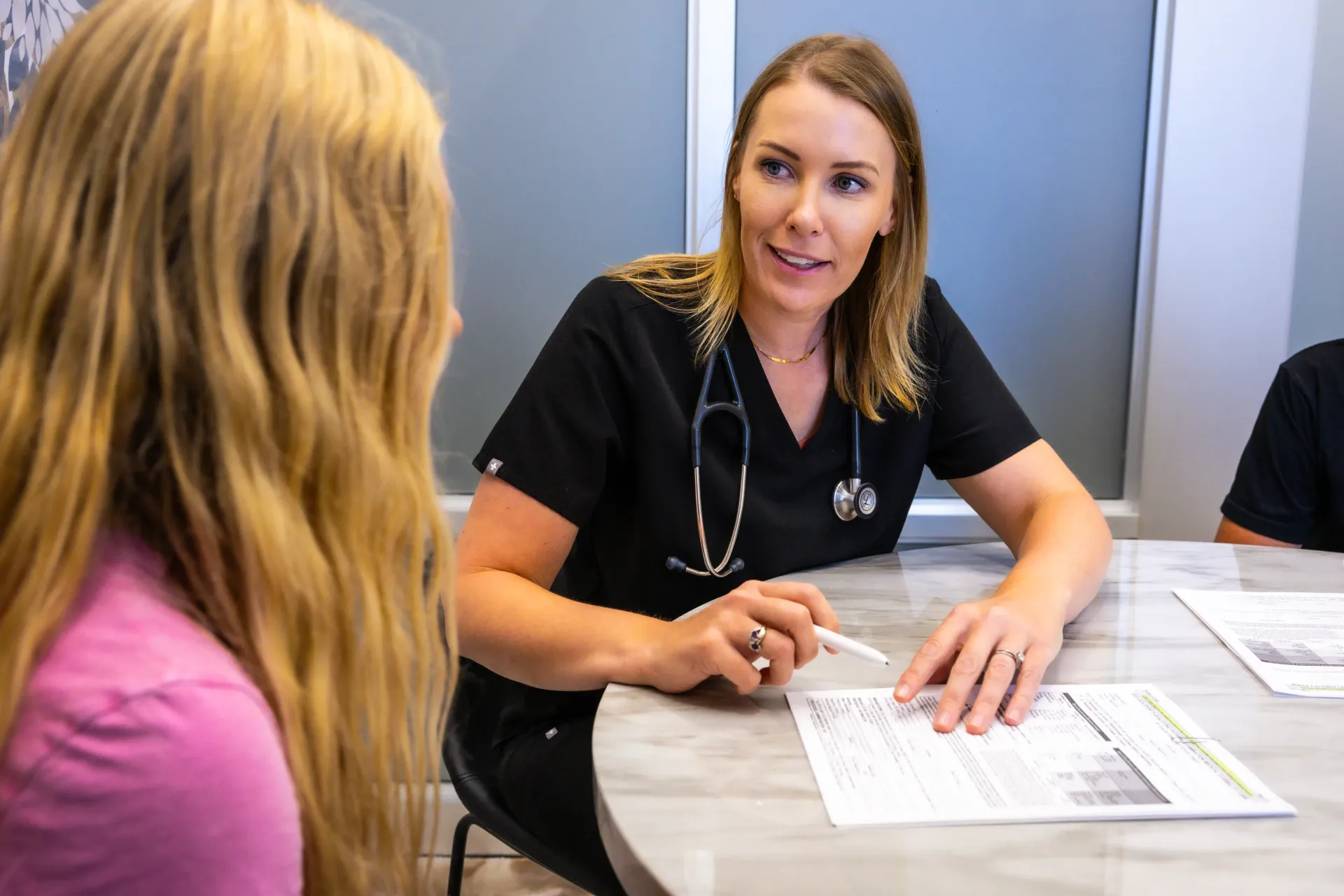 Healthcare worker discussing paperwork with a patient at a desk
