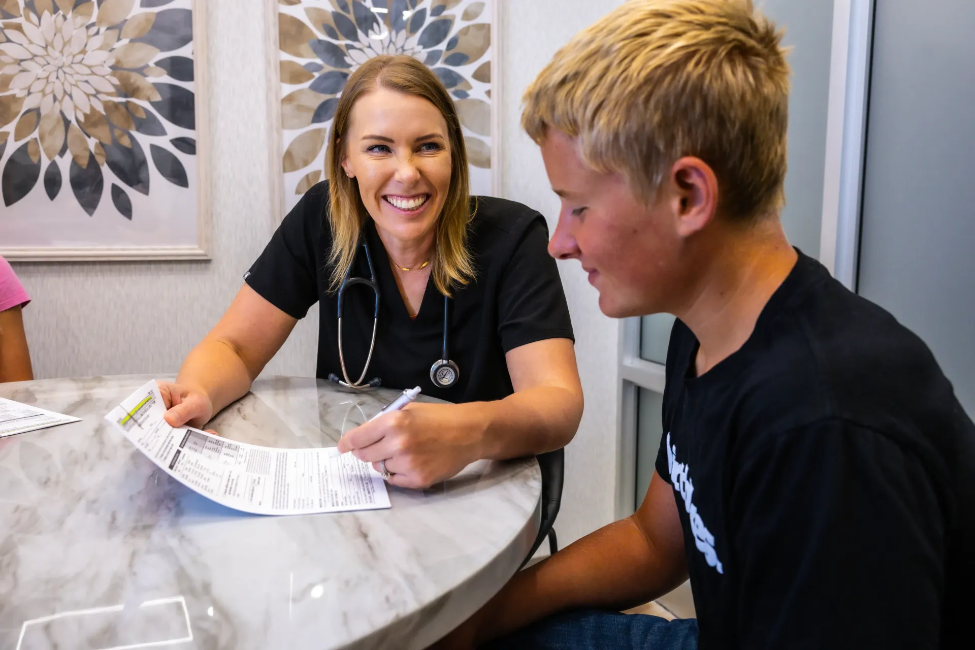Two people at a table reviewing papers, smiling in a bright office setting