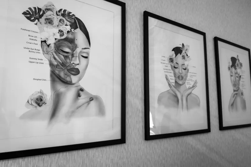 Three framed black-and-white portraits hang on a wall in a gallery-like setting.