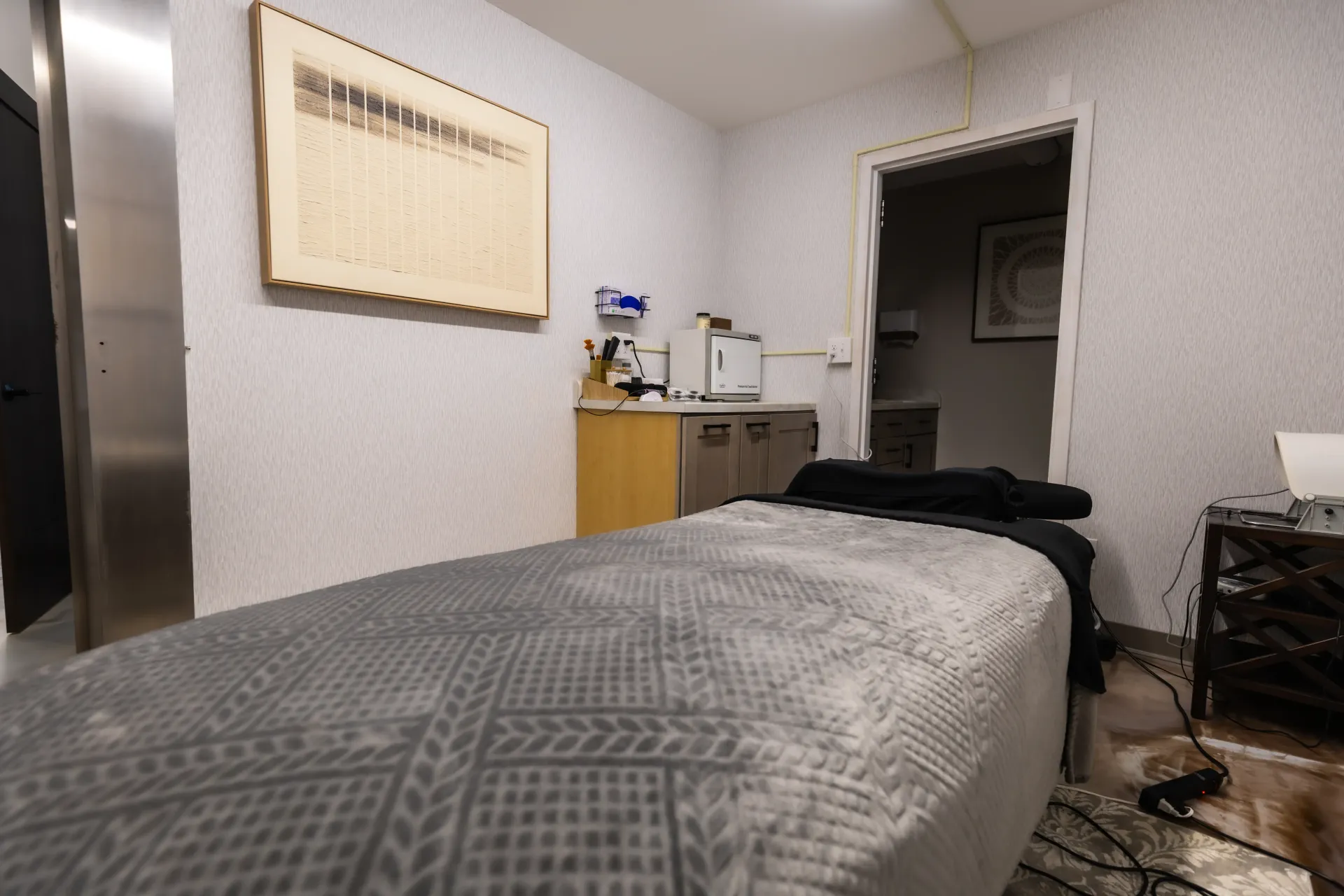 Small bedroom with a bed, dresser, wall cabinet, and open doorway to a hallway.