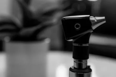 Black-and-white close-up of a tabletop microscope or inspection camera with blurred background