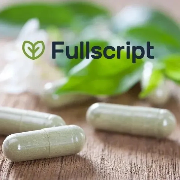 Fullscript logo above green capsules on a wooden surface
