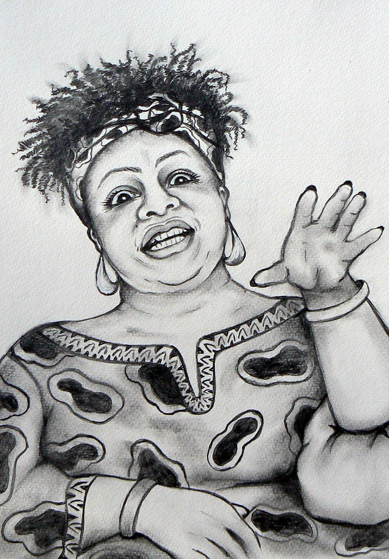 Woman with frizzy hair and patterned clothing, raising her hand and smiling.