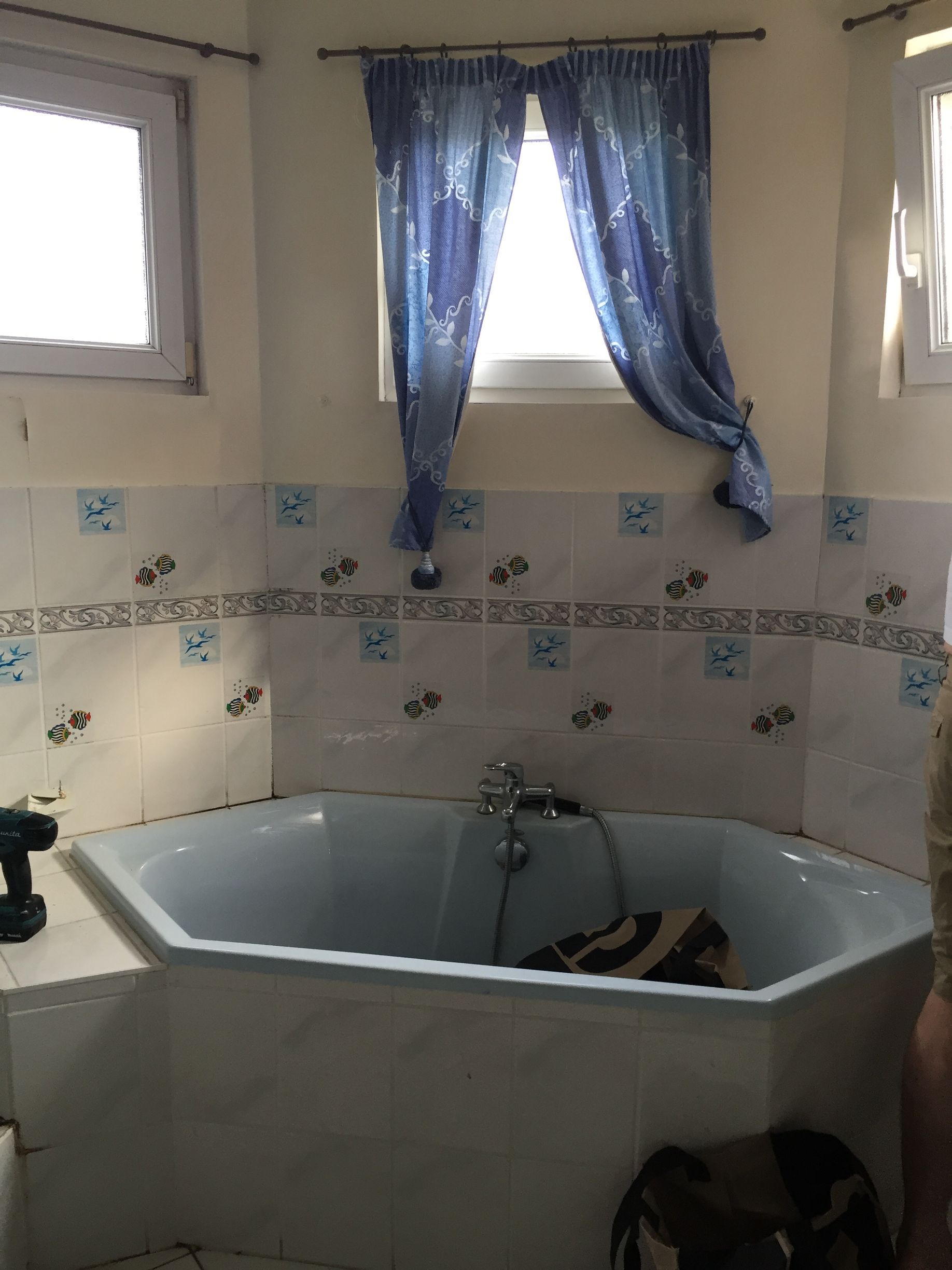 Avant : baignoire d'angle bleue et faïence à motifs, salle de bain à Gambsheim