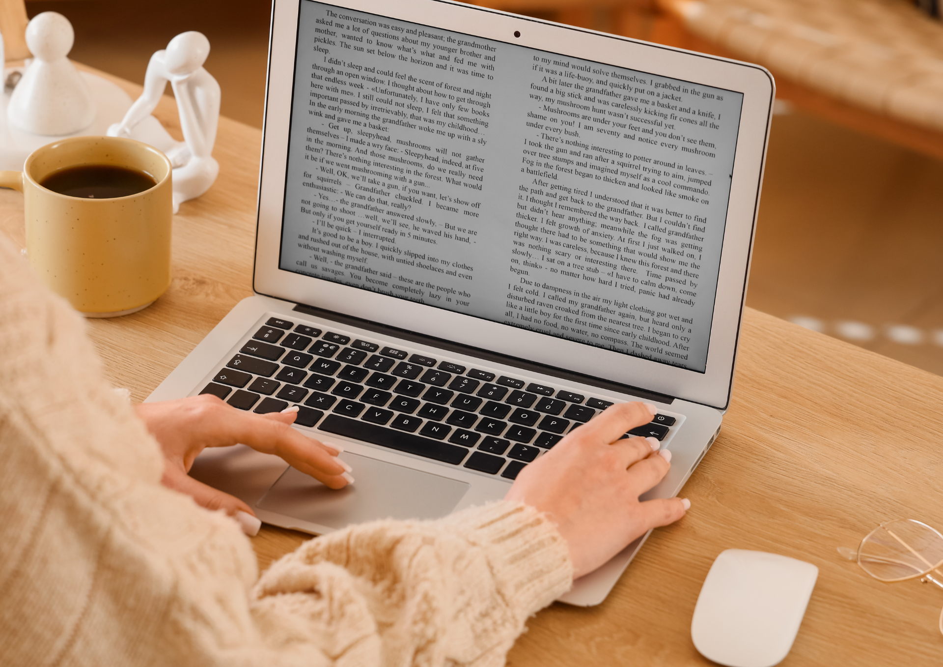 writer on a laptop beside a cup of coffee