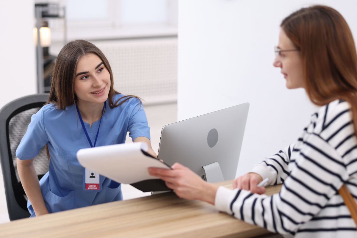 Medical Assistant Helping Patient at Reception in Clinic