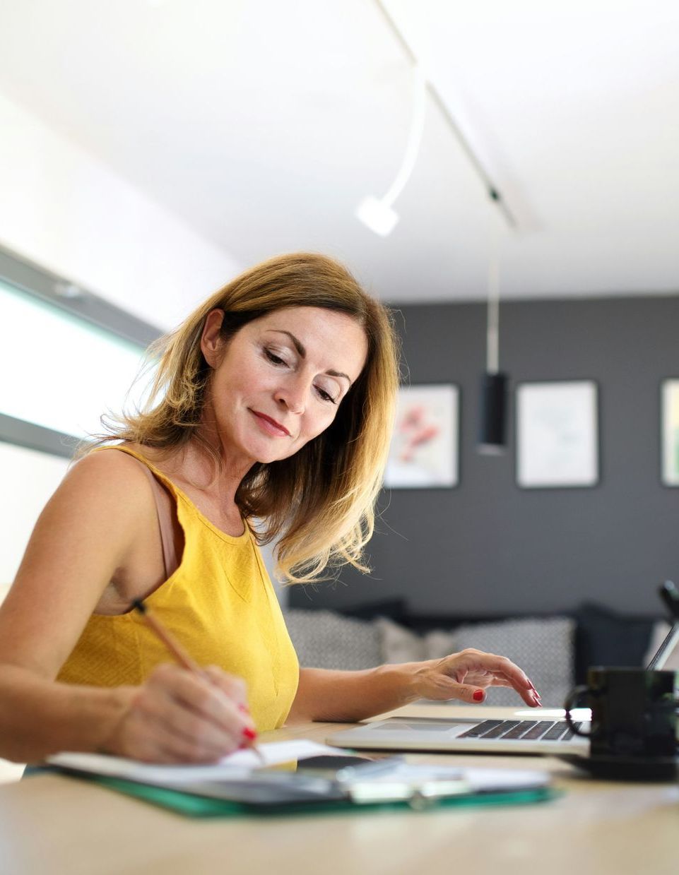 A woman is sitting at a table using a laptop computer.