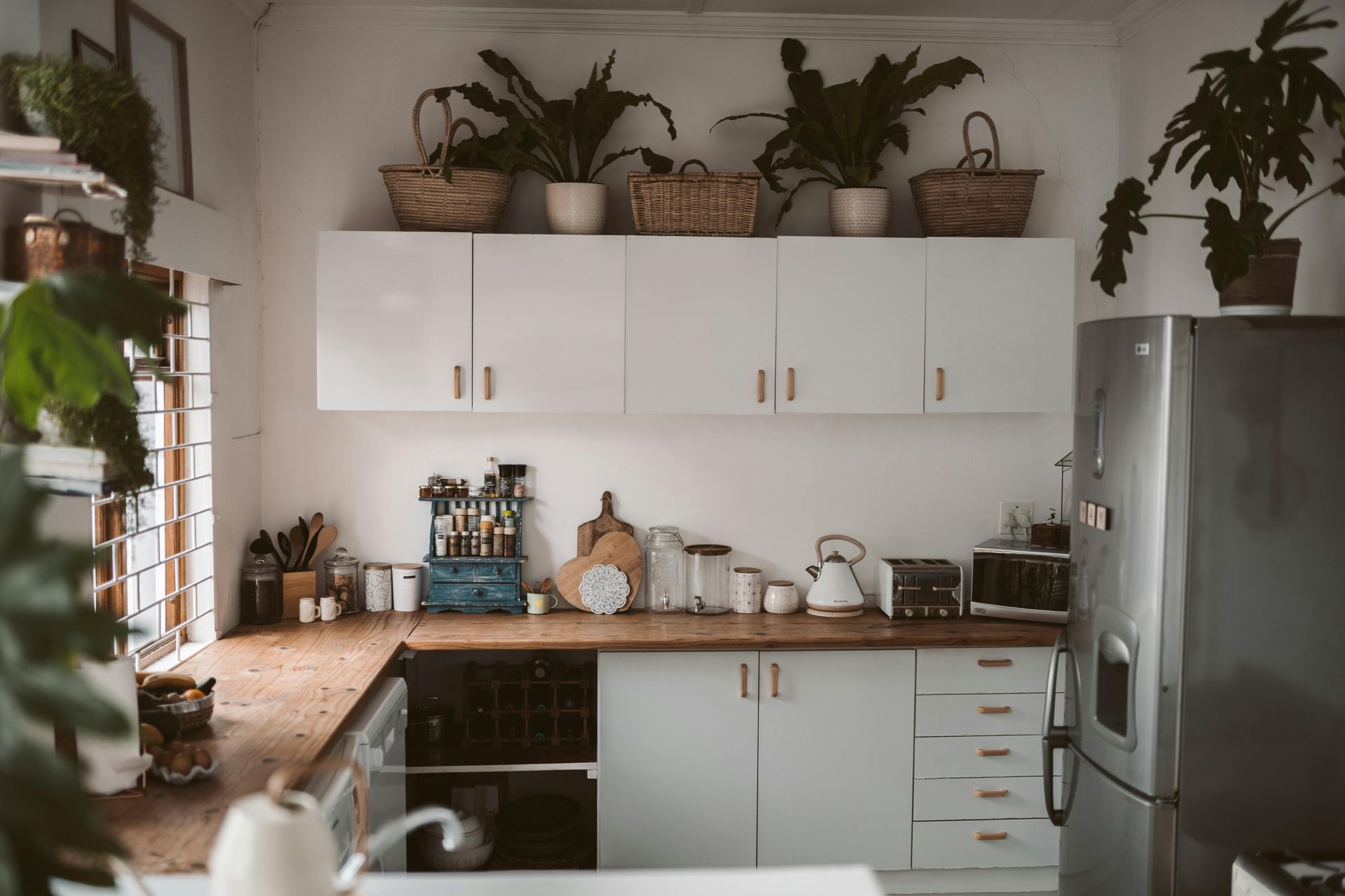 A kitchen with white cabinets and a stainless steel refrigerator.