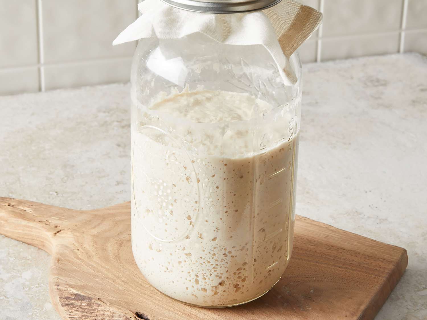 Sourdough discard in jar on cutting board. Sourdough discard can cause plumbing sink clog but MasterCraft Plumbing can help.