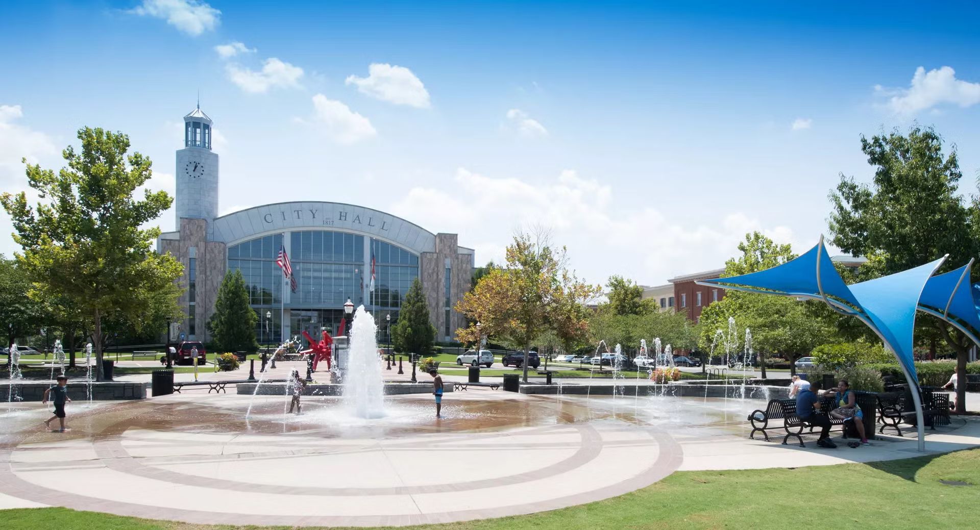 City Hall in Suwanee GA with the water fountain services by MasterCraft Plumbing on a sunny cloudy day