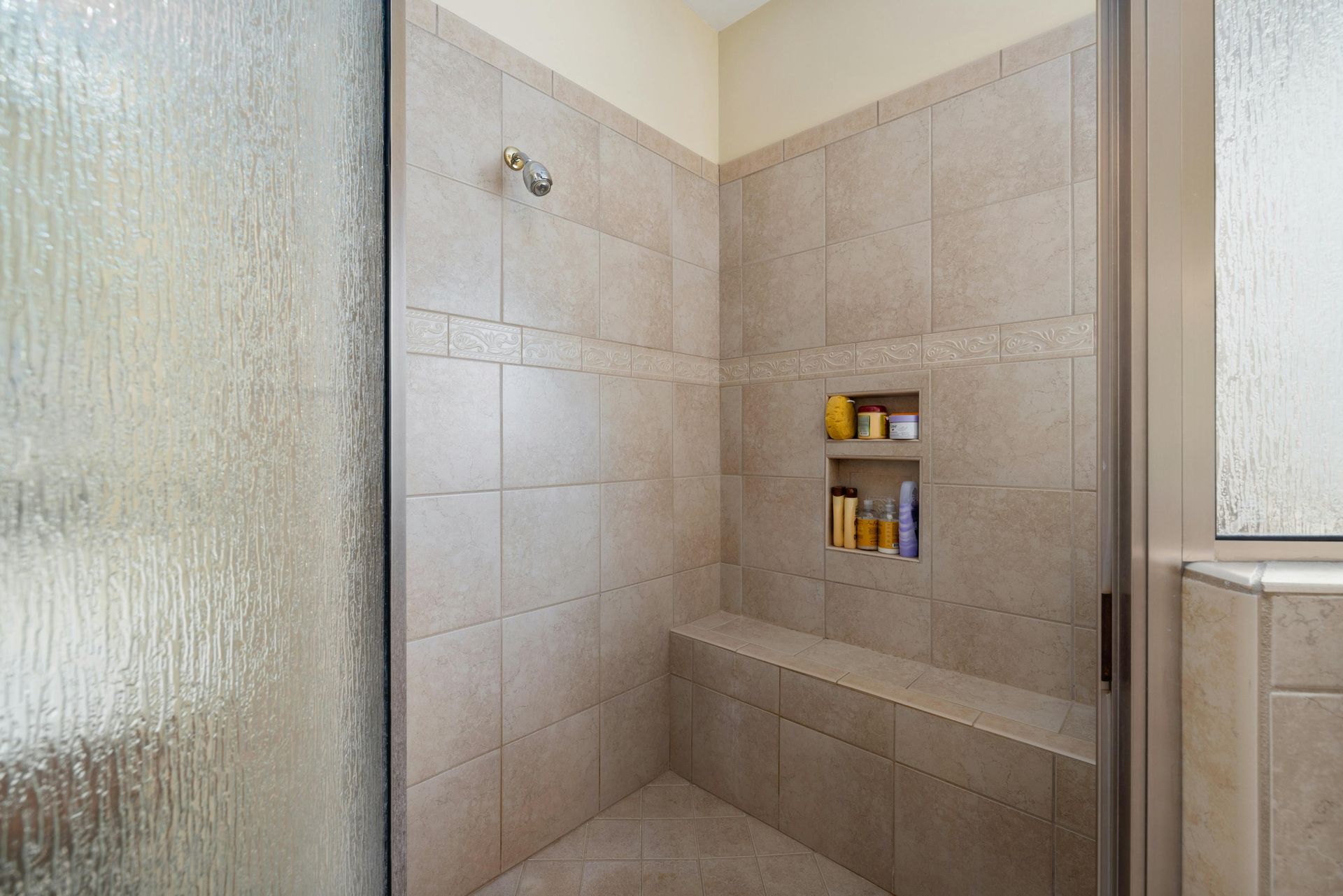 Shower leak plumbing repair with finished walk in shower with tiled walls.