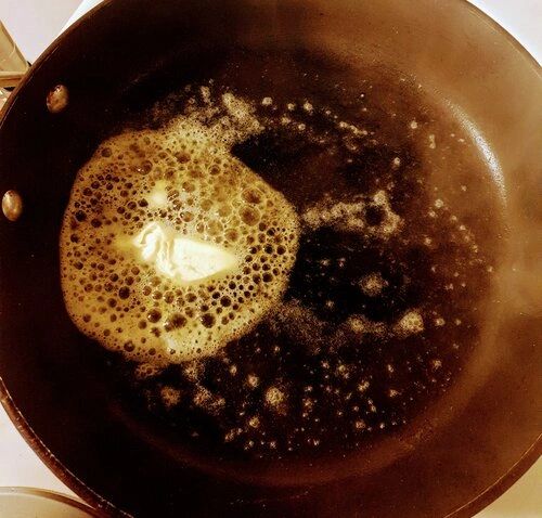 A frying pan filled with melted butter and bubbles