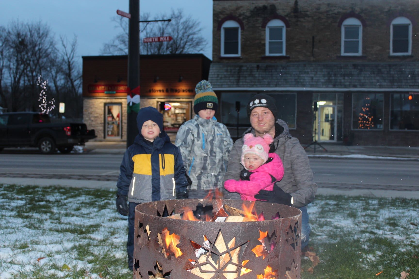 Families enjoying winter fire pit during Clifford Christmas event at Celebration Square