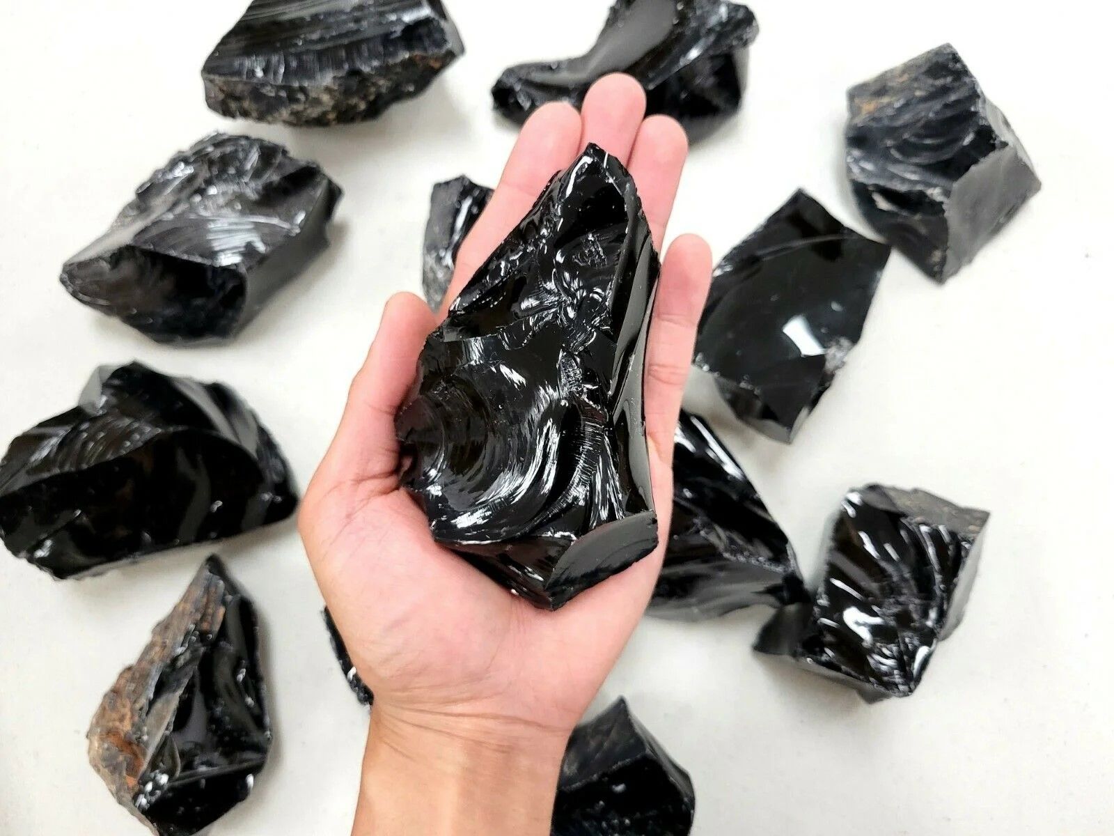 A person is holding a large piece of black rock in their hand.
