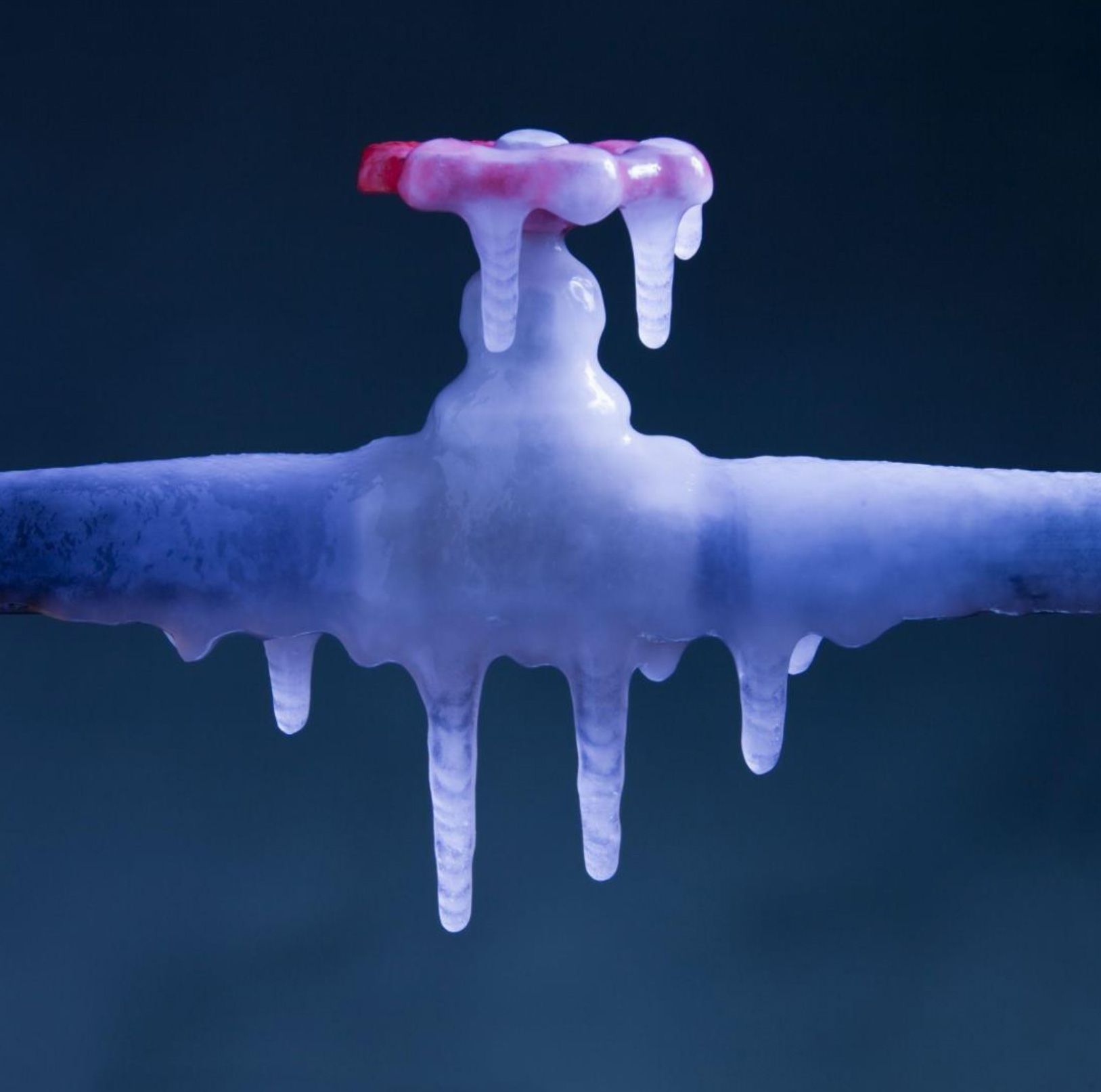 A frozen water pipe with icicles coming out of it