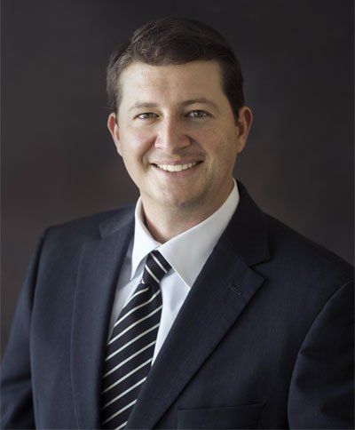 A man in a suit and tie smiles for the camera