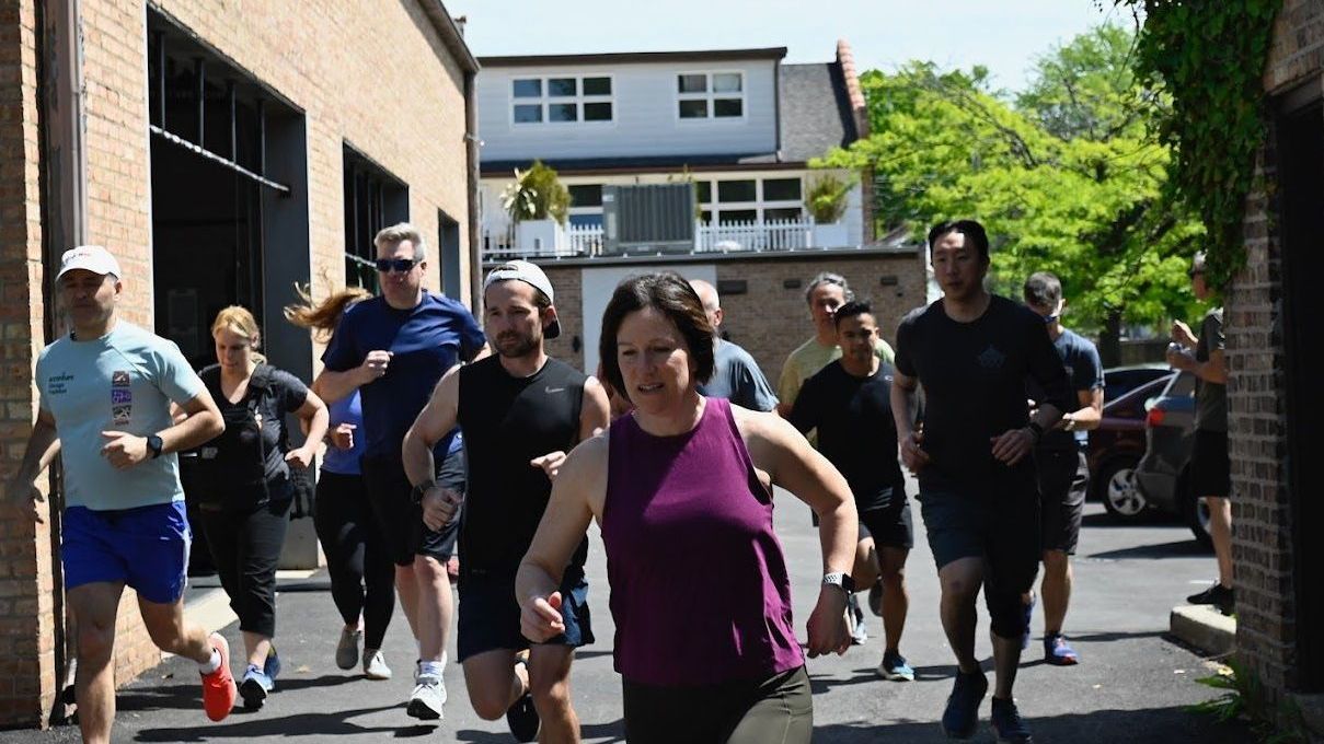 A group of people are running down a street.