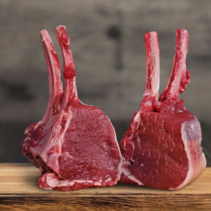 Two pieces of raw meat are sitting on a wooden table.