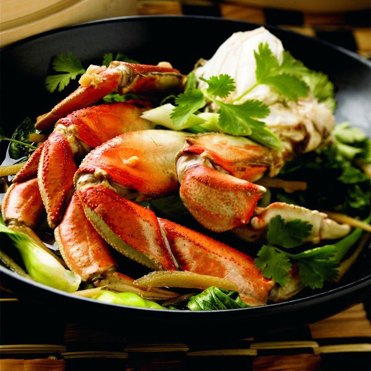 A black bowl filled with crabs and vegetables