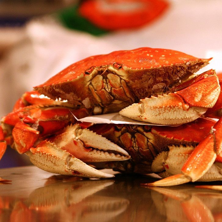 A crab is sitting on top of another crab on a table