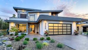 A modern house with a large garage door and a lot of windows.