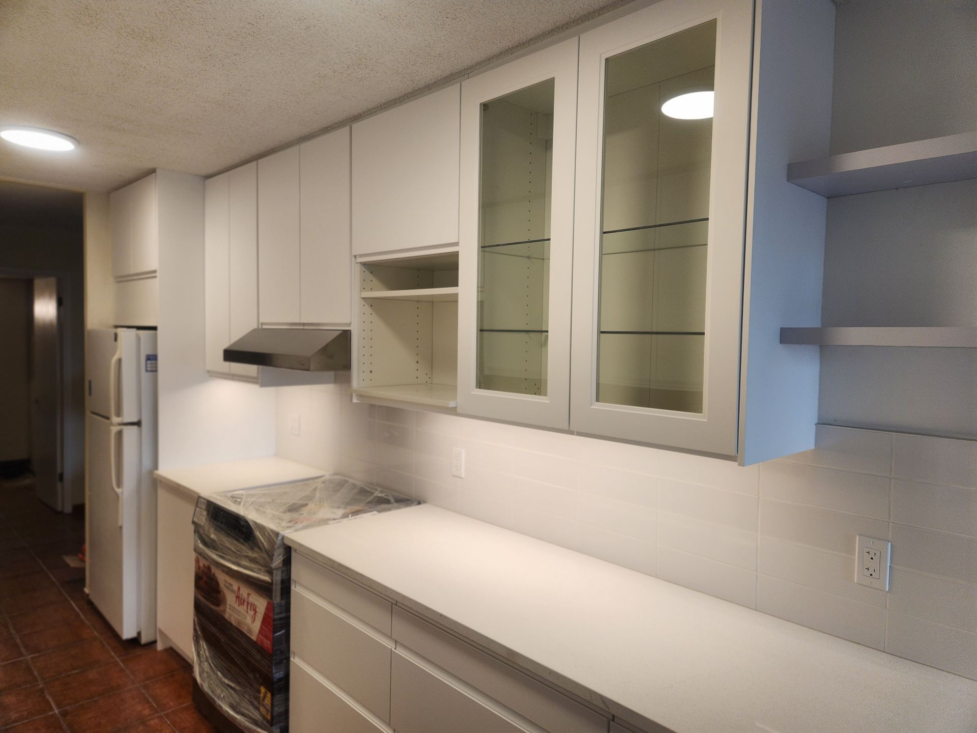 White kitchen with overhead cabinets, countertops, and appliances.