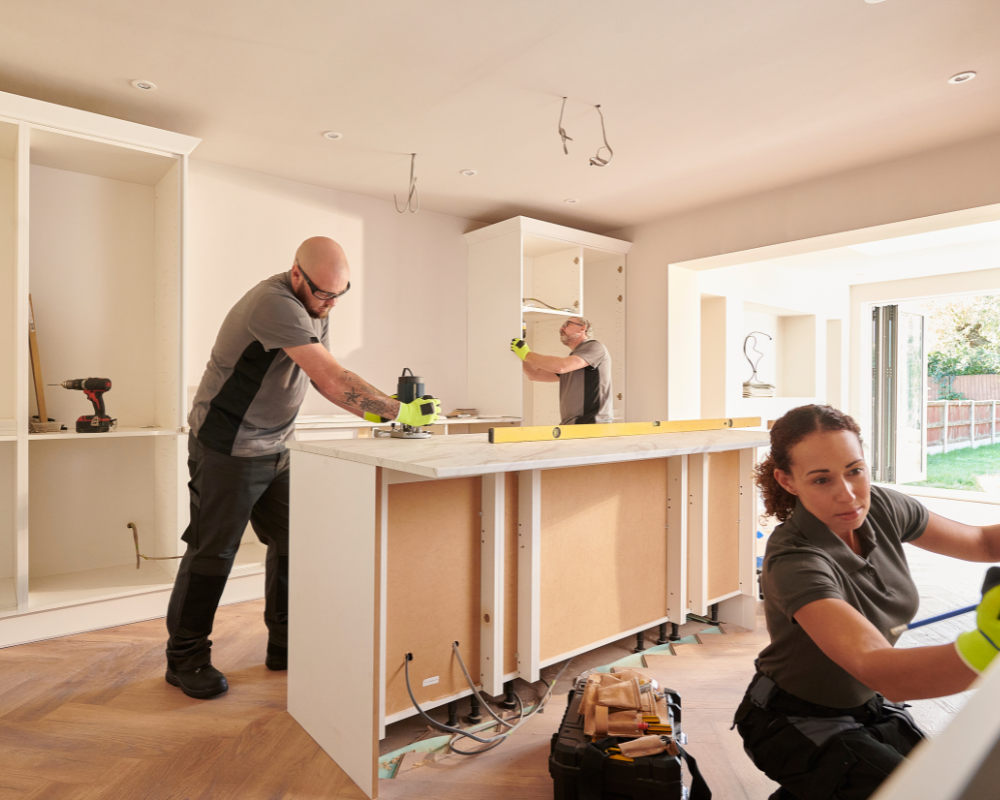 A man and a woman are working on a kitchen island.