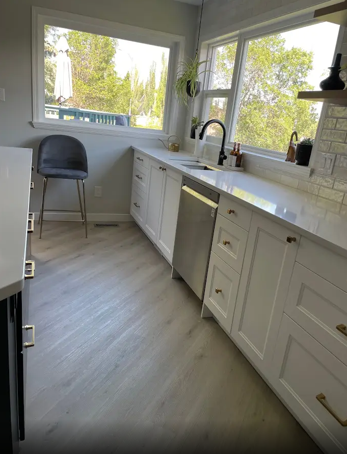 A kitchen with white cabinets and a stainless steel dishwasher.