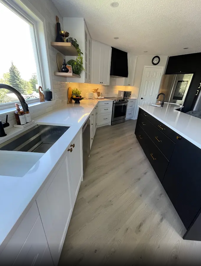 A kitchen with black cabinets and white counter tops