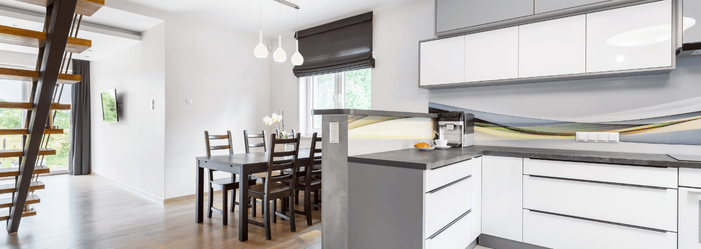 A kitchen with a table and chairs and a staircase in the background.