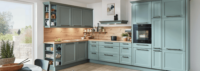 A kitchen with a lot of cabinets and drawers and a large window.