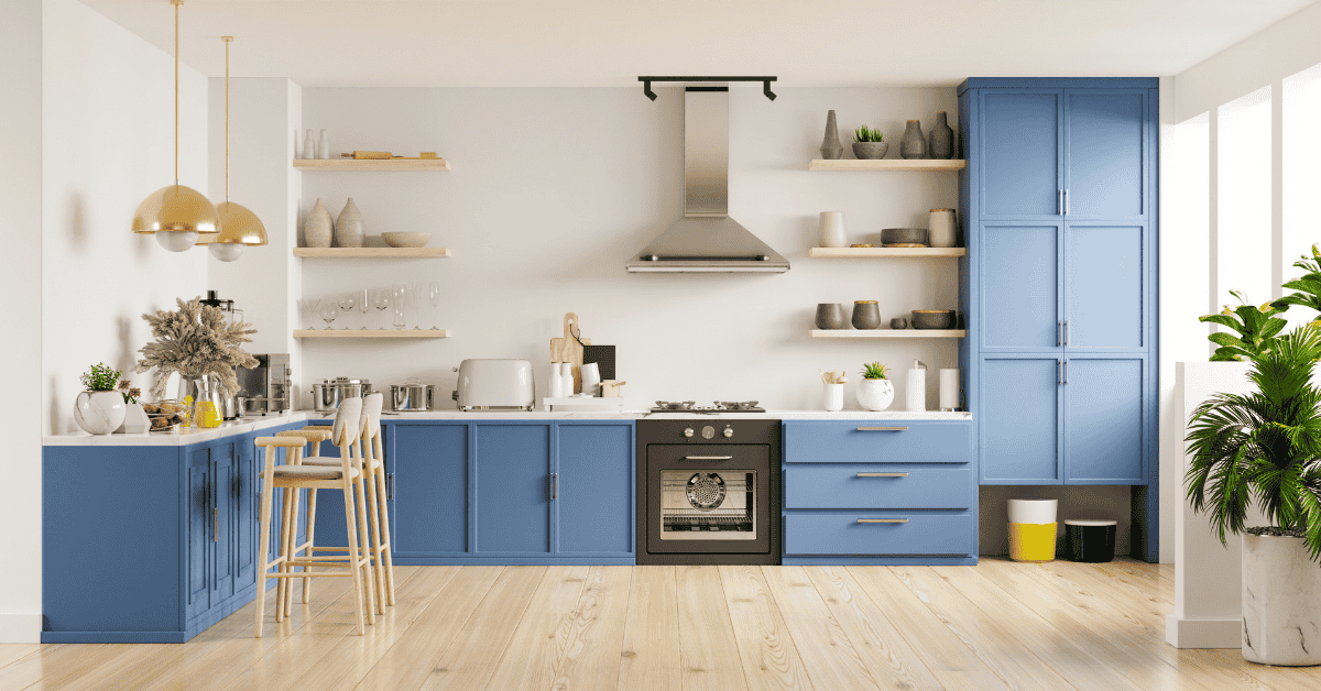 A kitchen with blue cabinets , wooden floors , a stove and a hood.