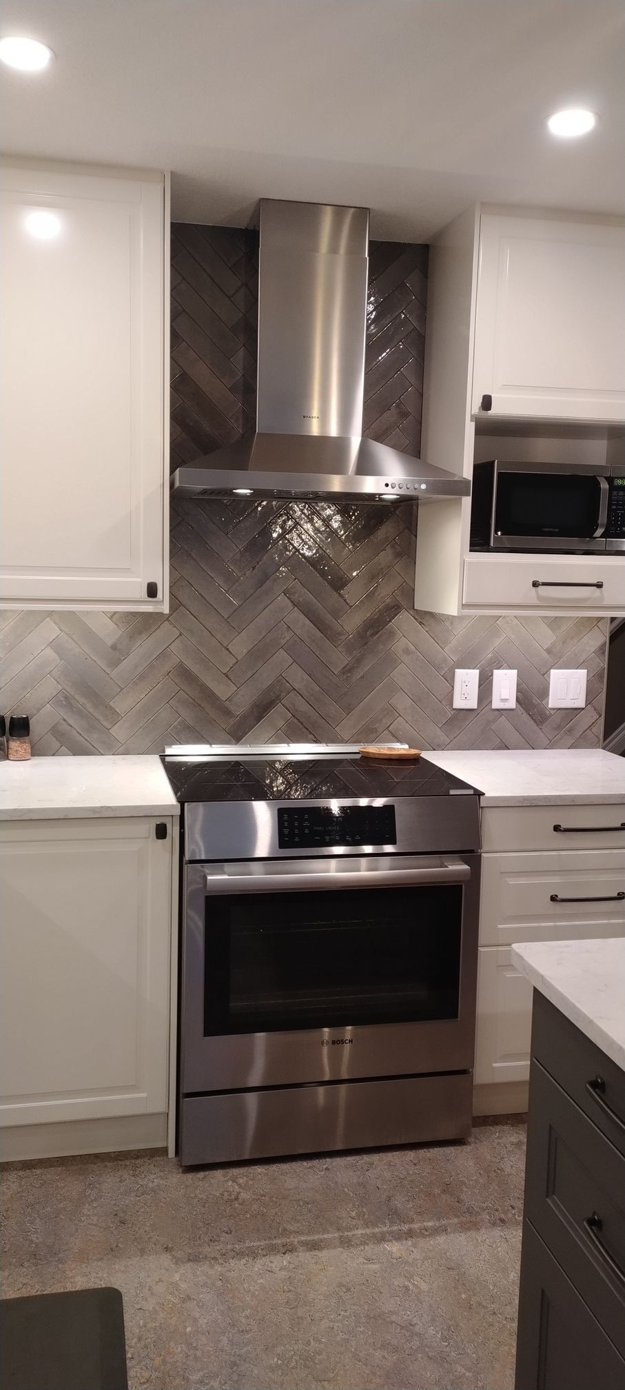 A kitchen with stainless steel appliances and white cabinets.