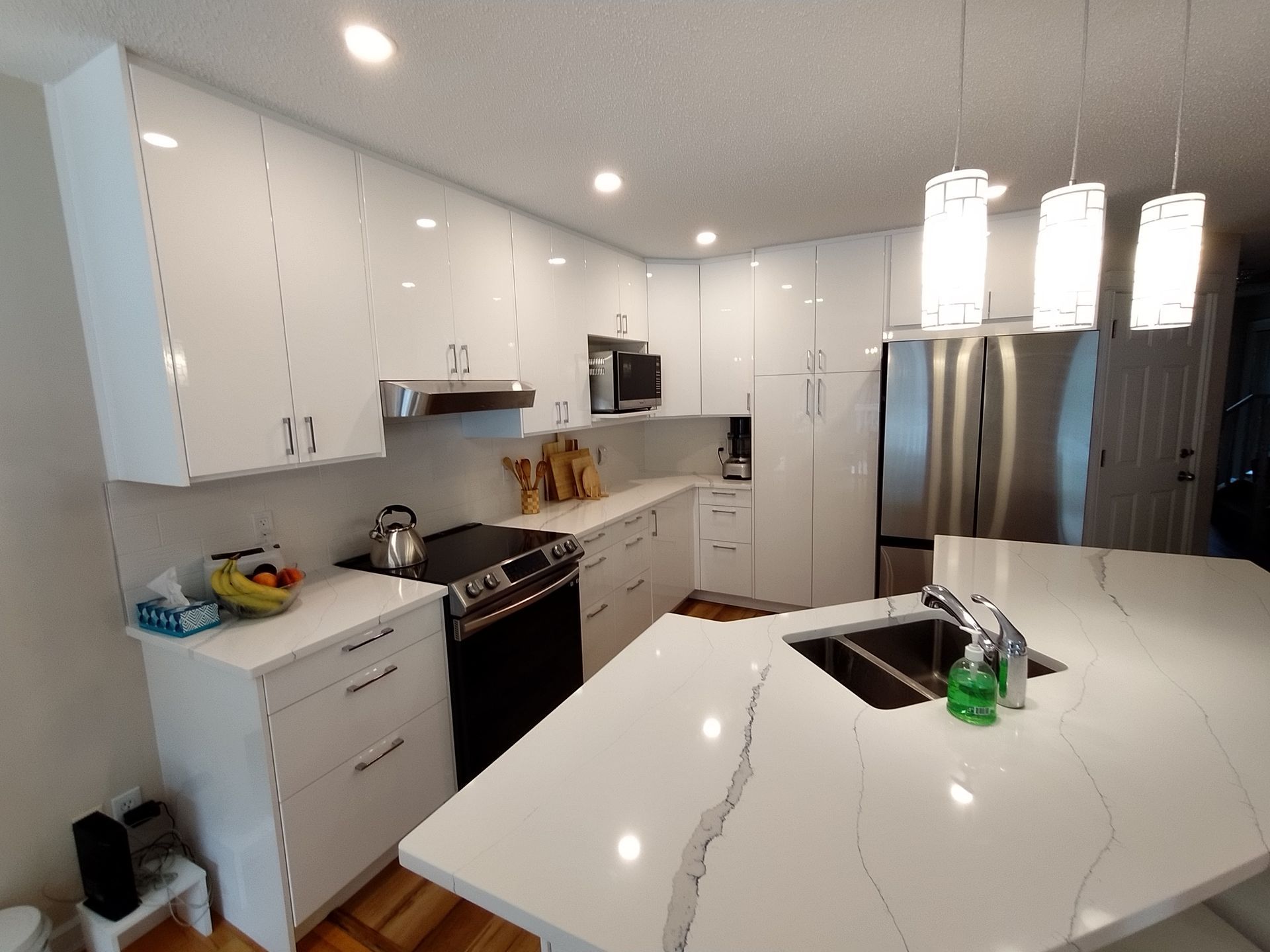 A kitchen with white cabinets and stainless steel appliances