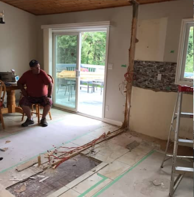 A man is sitting in a chair in a room with a hole in the floor