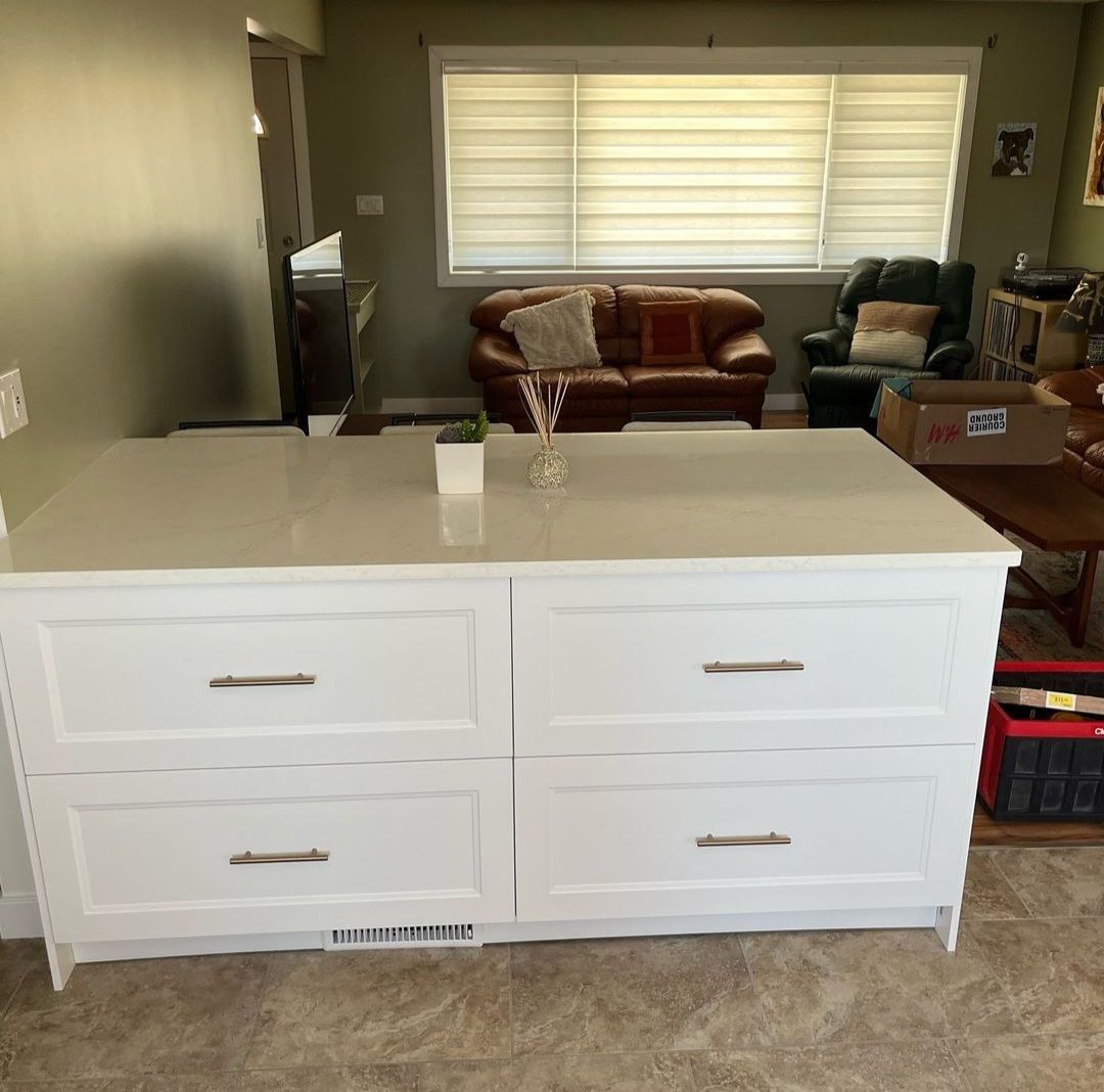A white dresser is sitting in a living room next to a couch.