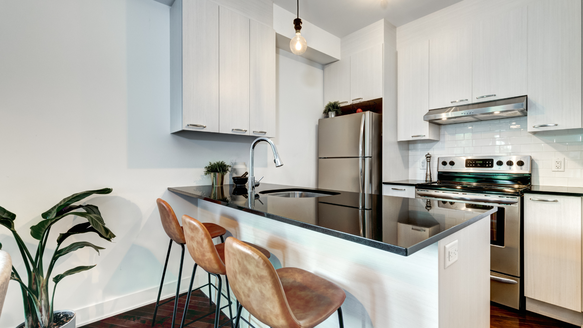 A kitchen with white cabinets , stainless steel appliances , a refrigerator , stove and sink.