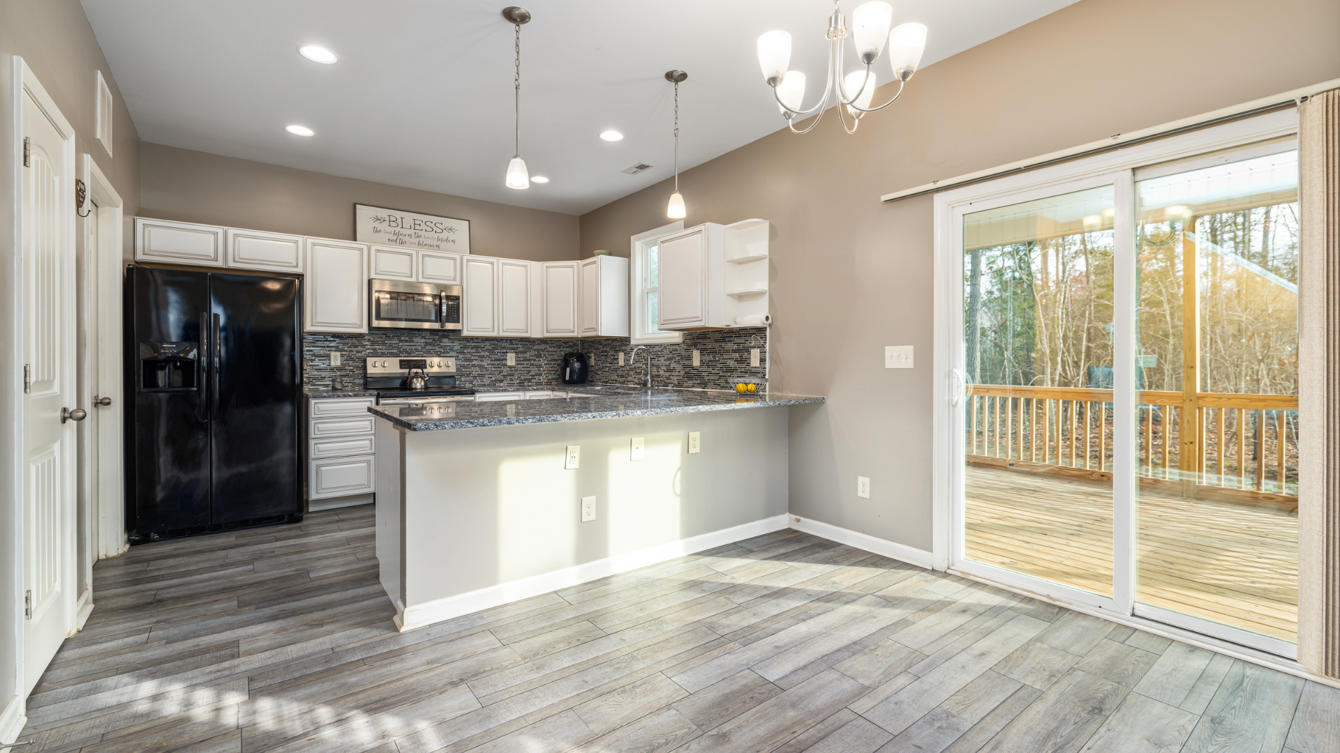 A kitchen with sliding glass doors leading to a deck.
