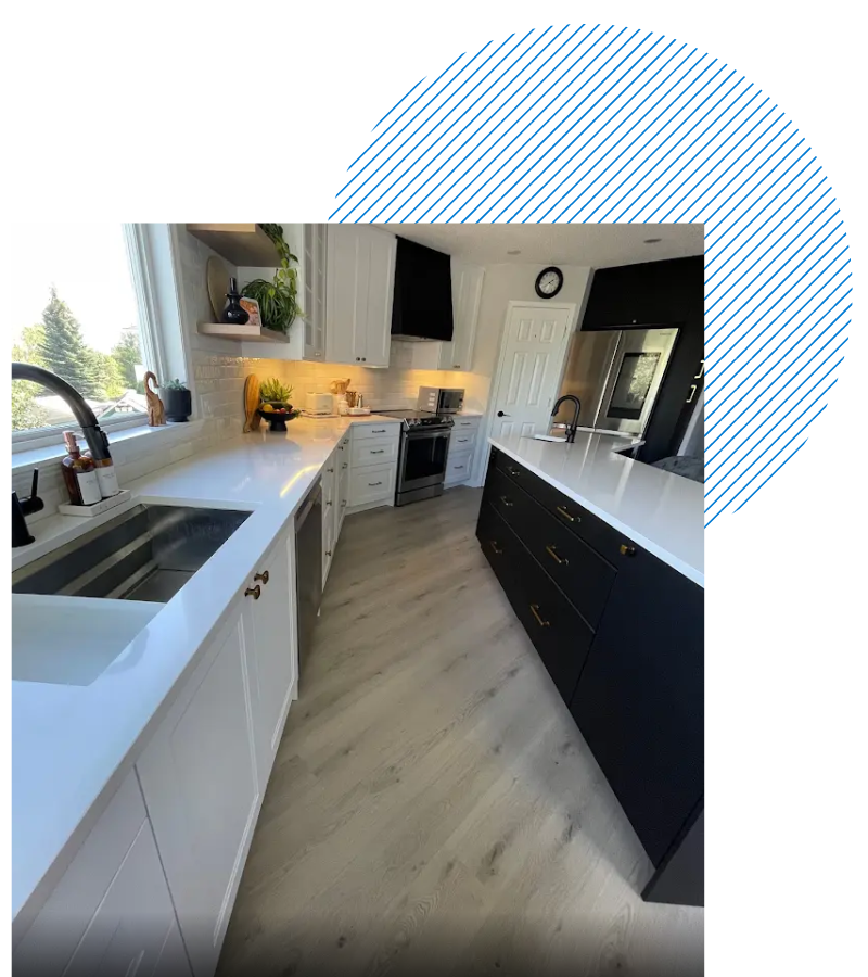 A kitchen with black cabinets and white counter tops and a sink.