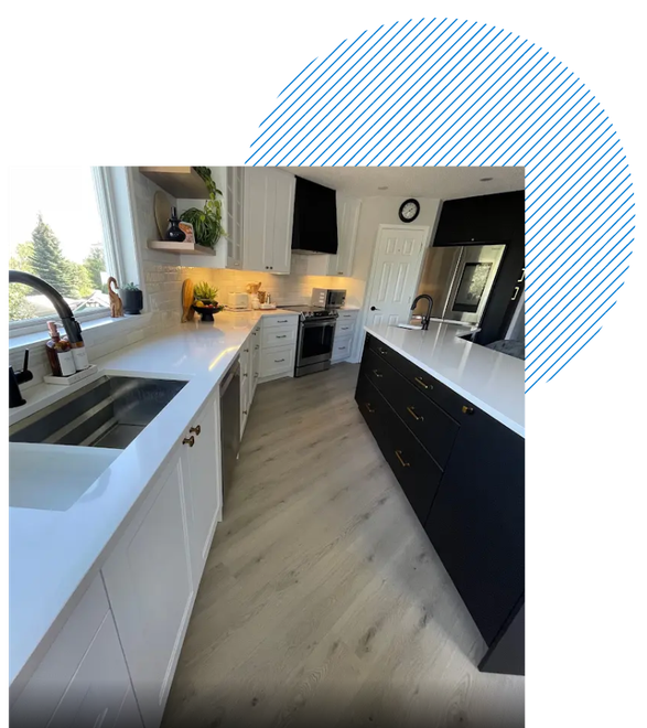 A kitchen with black cabinets and white counter tops and a sink.