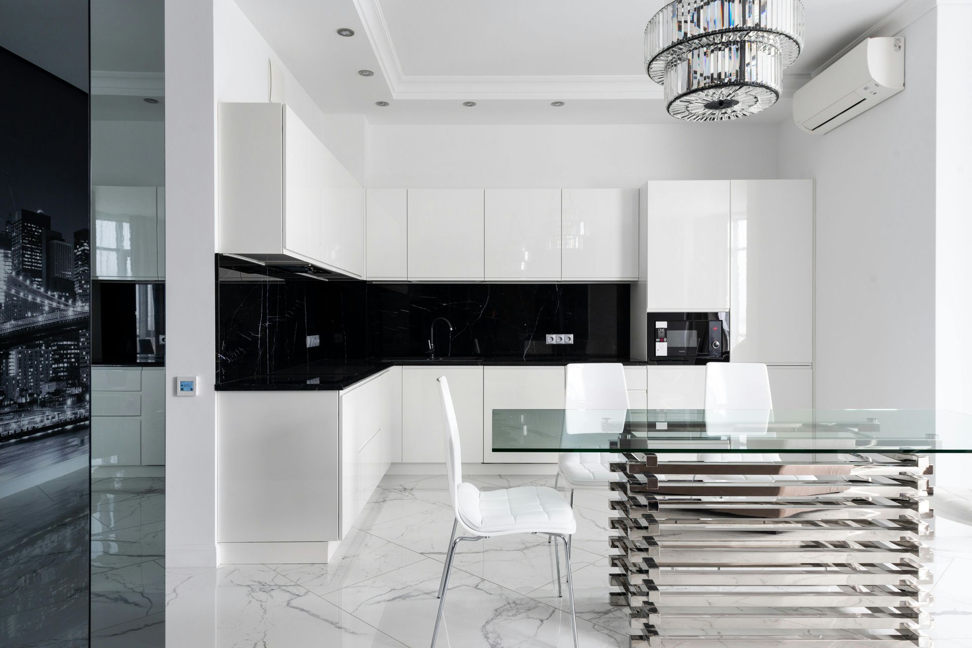 A black and white kitchen with a glass table and chairs.