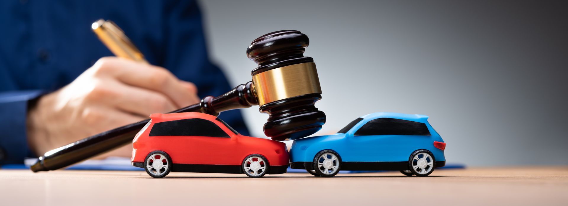 Judge’s gavel over red and blue toy cars in a legal dispute setting