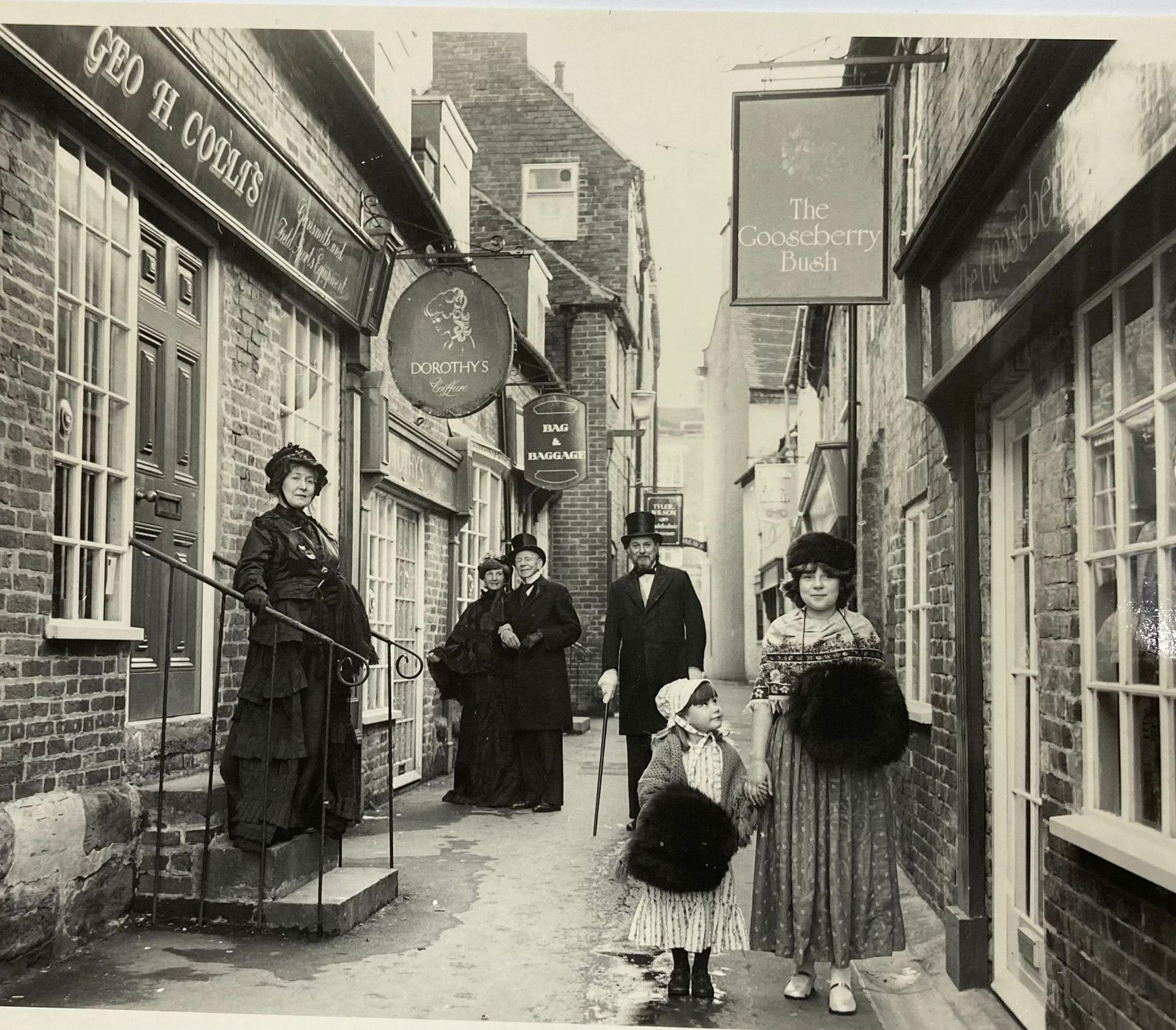 A black and white photo of people in front of a building that says geo h congas