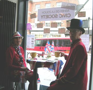 Two people sit at a table in front of a sign that says civic society